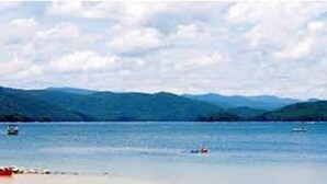 A calm lake with boats, surrounded by mountains. -  Sparrow Hawk Nest- Luxury Mountain View Tiny Home!  (Pickens)