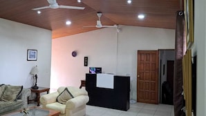 A living room with two sofas, a coffee table, a lamp, a TV, and a reception desk. - Kartagus Futura (San Salvador)