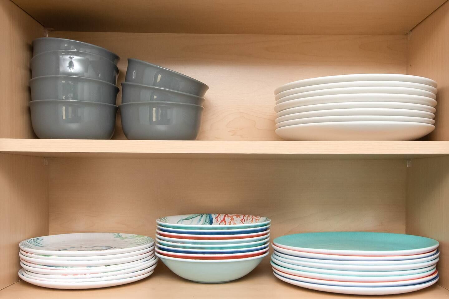 A storage box with shelves containing various plates and bowls.