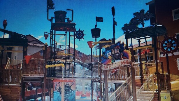 Um parque aquático com várias escorregas, uma fonte central e diversas estruturas de lazer.
