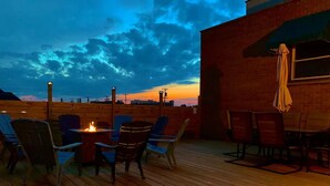 A wooden deck with outdoor seating and a fire pit.