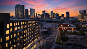 A cityscape at dusk with modern buildings and a clear sky.