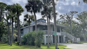 A two-story house with a covered porch and a staircase leading to the second floor. - Charming Beach House by Deer Lake Pool & Pond (Fripp Island)