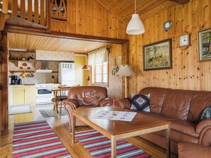 A cozy cabin interior with a wooden interior, a dining area, and a kitchen.