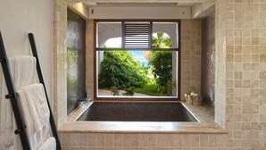Ein Badezimmer mit großem Fenster, Handtuchhalter und Duschbereich.