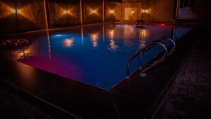 A swimming pool with a metal ladder and a red object floating in the water. - BINTOO HOTEL LIMITED (Sagamu)