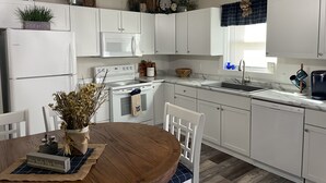 Eine moderne Küche mit weißen Schränken, einem Holztisch und einem eingebauten Backofen.