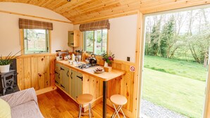Una cocina acogedora con armarios de madera, una barra y un amplio ventanal con vistas al exterior.