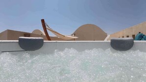 Ein Wasserspiel mit zwei Fontänen, einer Holzkonstruktion und einem hellen Gebäude im Hintergrund.