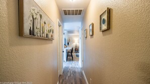 A hallway with a wooden floor, a ceiling light, and framed artwork on the walls. - Fantastic Views w/ Hottub,  Firepit & Horseshoes (Ahwahnee)