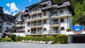 A multi-story hotel with balconies, a mountain view, and a sign indicating it's a luxury establishment. - Le Cristal MB6 View, Pool, Private Sauna, Parking & Free WiFi, Argentière (Chamonix), France (Argentière (Chamonix))