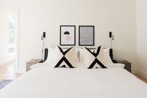 A modern bedroom with a large bed, two nightstands, and two wall-mounted light fixtures. - Family-friendly Nashville home near Belmont, sleeps 10 with bunk room (Nashville)