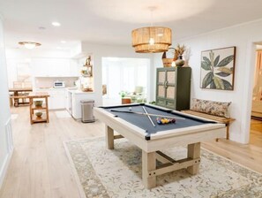 Relax in this spacious living area with a pool table, kitchenette, and dining space.