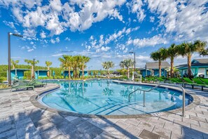 A circular pool with a clear blue sky and scattered clouds above. - Super Luxury Modern Home Prime Location (Kissimmee)