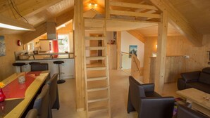 A wooden interior with a dining area, kitchen, and a staircase leading to an upper level. - Alpenchalet 341 by Interhome (Klippitztörl)