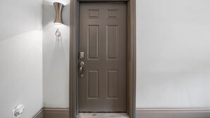 A closed door with a keyhole and a doorbell. - Stylish 2BR near City Center | OTR, UC, Zoo (Cincinnati)