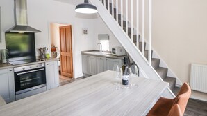 Une cuisine moderne dotée d’un îlot central, d’un four encastré et d’un four à micro-ondes.
