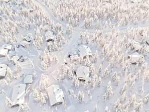Un paisaje nevado con varias casas rodeadas de árboles.