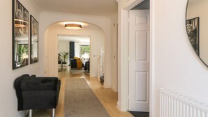A hallway with a carpet, a black chair, and a white door.