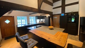 A modern kitchen with a large island, built-in appliances, and a view of the outdoors.