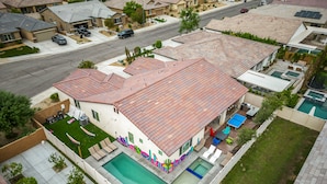 Uma casa com piscina, varanda coberta e quintal cercado.