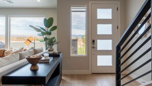 Una sala de estar con sofá, una mesa de centro con un cuenco, una lámpara y vistas a través de una puerta.