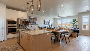Una cocina moderna con una isla central, electrodomésticos integrados y un comedor con vistas.