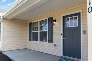A house with a front porch, a dark front door, and a mailbox.