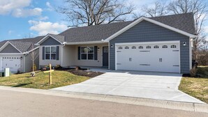 A two-story house with a garage, a front yard, and a clear sky. - BRAND NEW home among the Nook in Hamilton, OH (Hamilton)