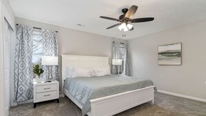 A bedroom with a bed, nightstands, a ceiling fan, and a painting on the wall. - BRAND NEW Home away from Home among the Nook (Hamilton)