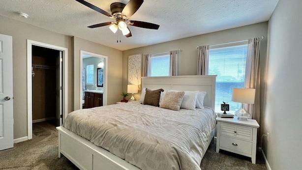 A bedroom with a bed, nightstands, a ceiling fan, and a door leading to another room. - 430 Ridgelawn · Brand New Home Walking distance to Spooky Nook (Hamilton)