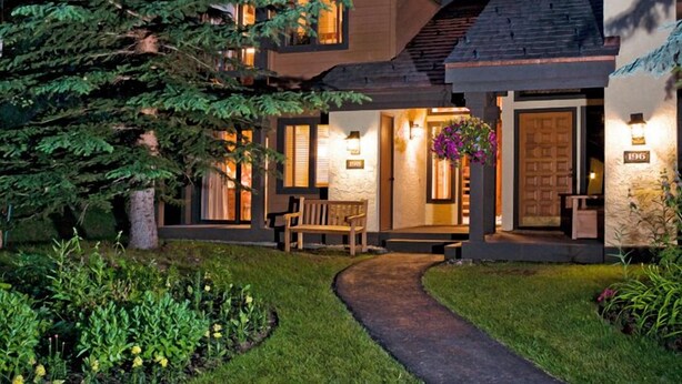 A modern multi-story house with a well-lit entrance, a visible number '196', and a pathway leading to the front door. - Ridgepoint Townhome 142 - 3.5 Bedroom plus Loft Residence (Avon)