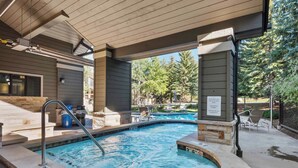 A hot tub with a wooden deck, a pool, and outdoor seating. - Ridgepoint Townhome 142 - 3.5 Bedroom plus Loft Residence (Avon)