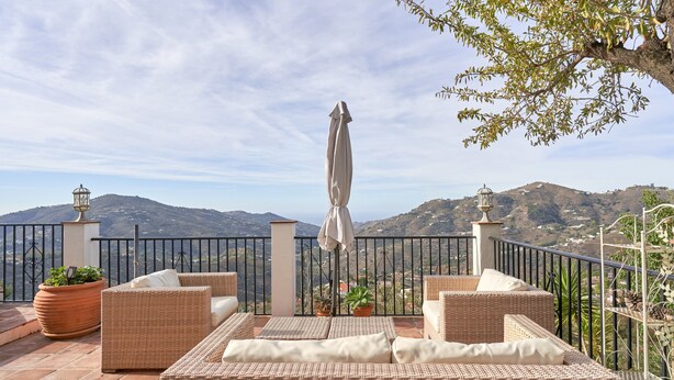 A terrace with wicker furniture, potted plants, and a view of mountains. - Holiday Home 'Casa Oliana' with Sea View, Pool, Garden & Wi-Fi (Competa)