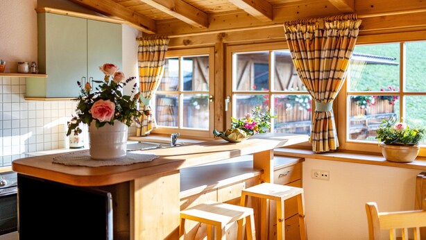 A wooden kitchen with a wooden countertop, a sink, and a window with curtains. - Holiday Apartment "Adults Only Wasserfall Hegedex" with Mountain View, Balcony & Wi-Fi (Pfunders)