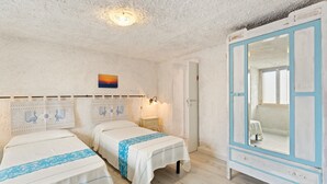 Une chambre avec deux lits, une armoire, un tableau et un luminaire au plafond.