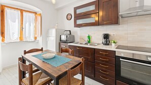 Une cuisine avec des meubles de rangement en bois, un four à micro-ondes, une machine à café et un évier.