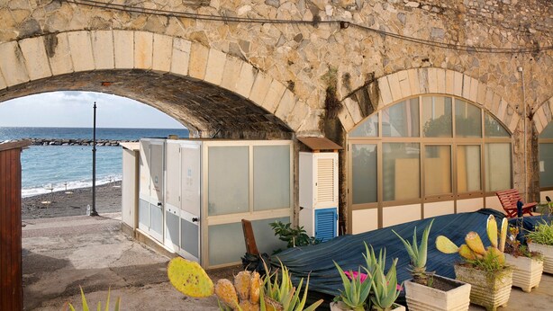A stone archway leading to a beach, a hammock, and potted plants. - Buddha, Borgo Dei Pescatori Apartment with Wi-Fi (Cervo)
