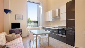 A modern kitchen with a dining area, a sofa, and a TV. - Buddha, Borgo Dei Pescatori Apartment with Wi-Fi (Cervo)