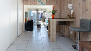 A modern kitchen with a central island, bar stools, and a potted plant. - Studio 'Cap Breton' – adjoining house with private terrace, Wi-Fi, and air conditioning (Capbreton)