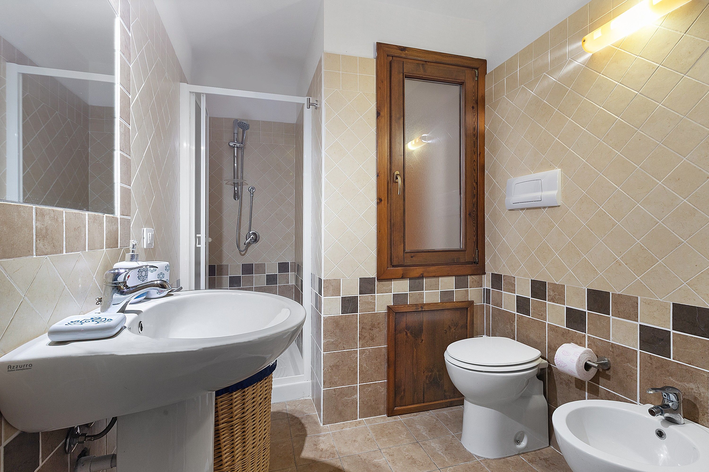 Ein Badezimmer mit Waschbecken, Toilette, Bidet und Spiegel.