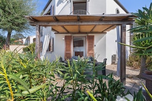 A house with a covered porch, a visible door, and a window. - Holiday Home "Villa Vigna" with Sea View, Pool and Wi-Fi (Badesi)