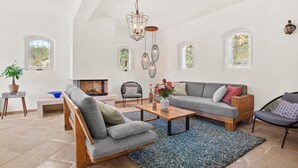 A spacious living room with a fireplace, a chandelier, and a large window. - Mon Gîte en Provence - Fantastic Villa with Pool, Grand Piano and Fireplace in the Green Provence (Salernes)