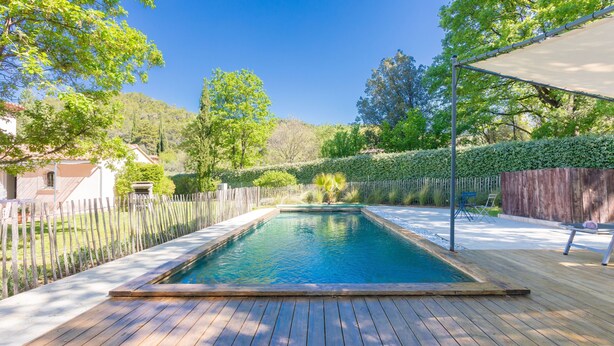 A rectangular swimming pool with a wooden deck, surrounded by a wooden fence and a hedge. - Mon Gîte en Provence - Fantastic Villa with Pool, Grand Piano and Fireplace in the Green Provence (Salernes)
