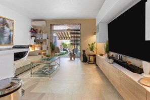 A modern living room with a sofa, coffee table, TV, and decorative items.