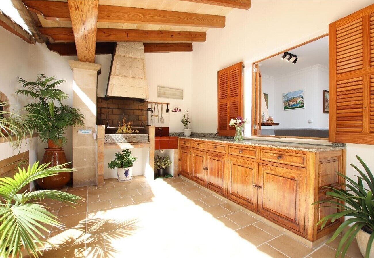 A kitchen with wooden cabinets, a tiled floor, and potted plants.