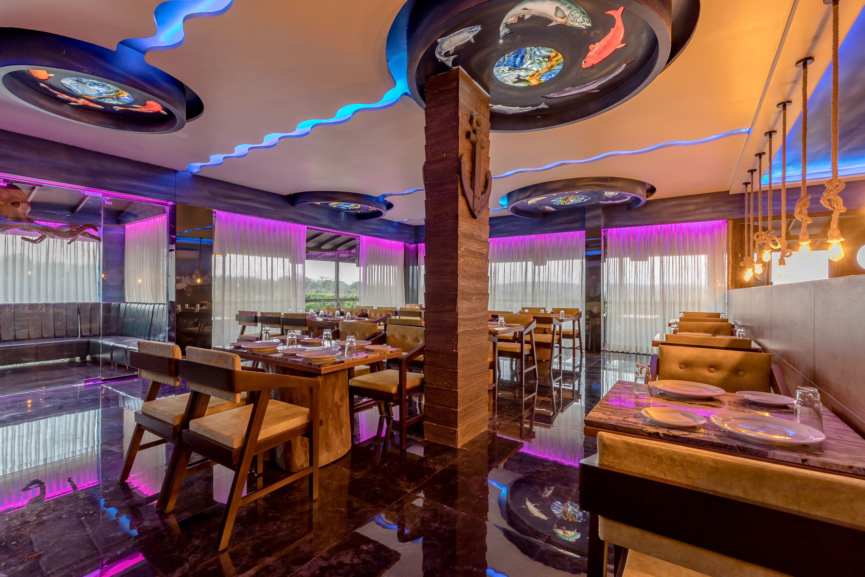 Un restaurant au décor moderne, avec des tables et des chaises en bois, et une colonne centrale.
