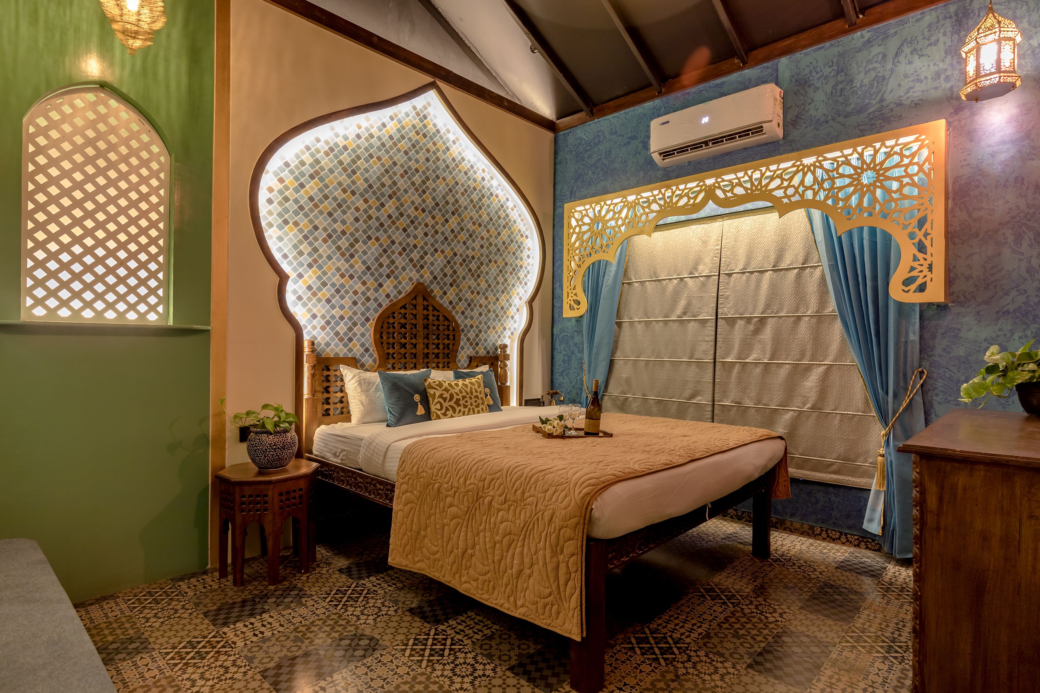 Une chambre à coucher avec un lit, une petite table sur laquelle est posée une plante, un mur décoratif et une fenêtre ornée d’un motif en treillis.