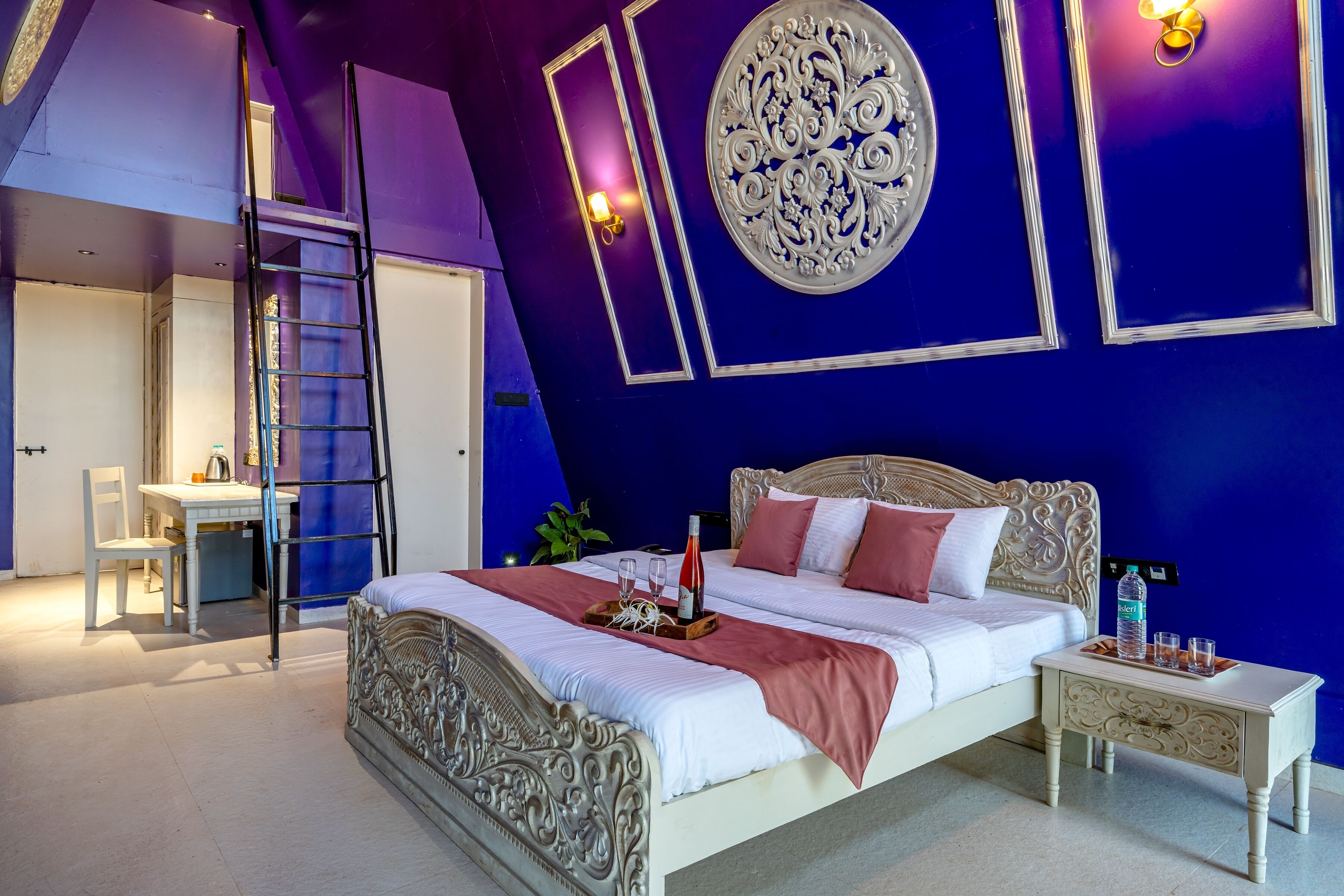 A bedroom with a bed, bedside table, and a desk with a chair.