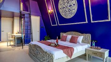 A bedroom with a bed, bedside table, and a desk with a chair.